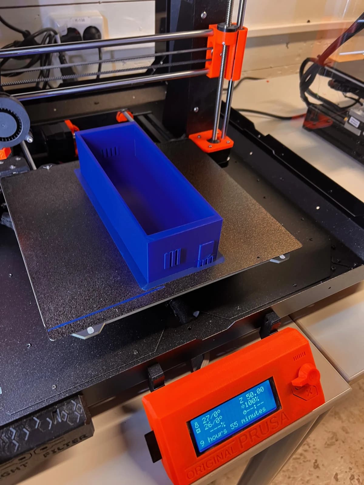 En blå gjenstand på byggeplaten til en 3D-printer